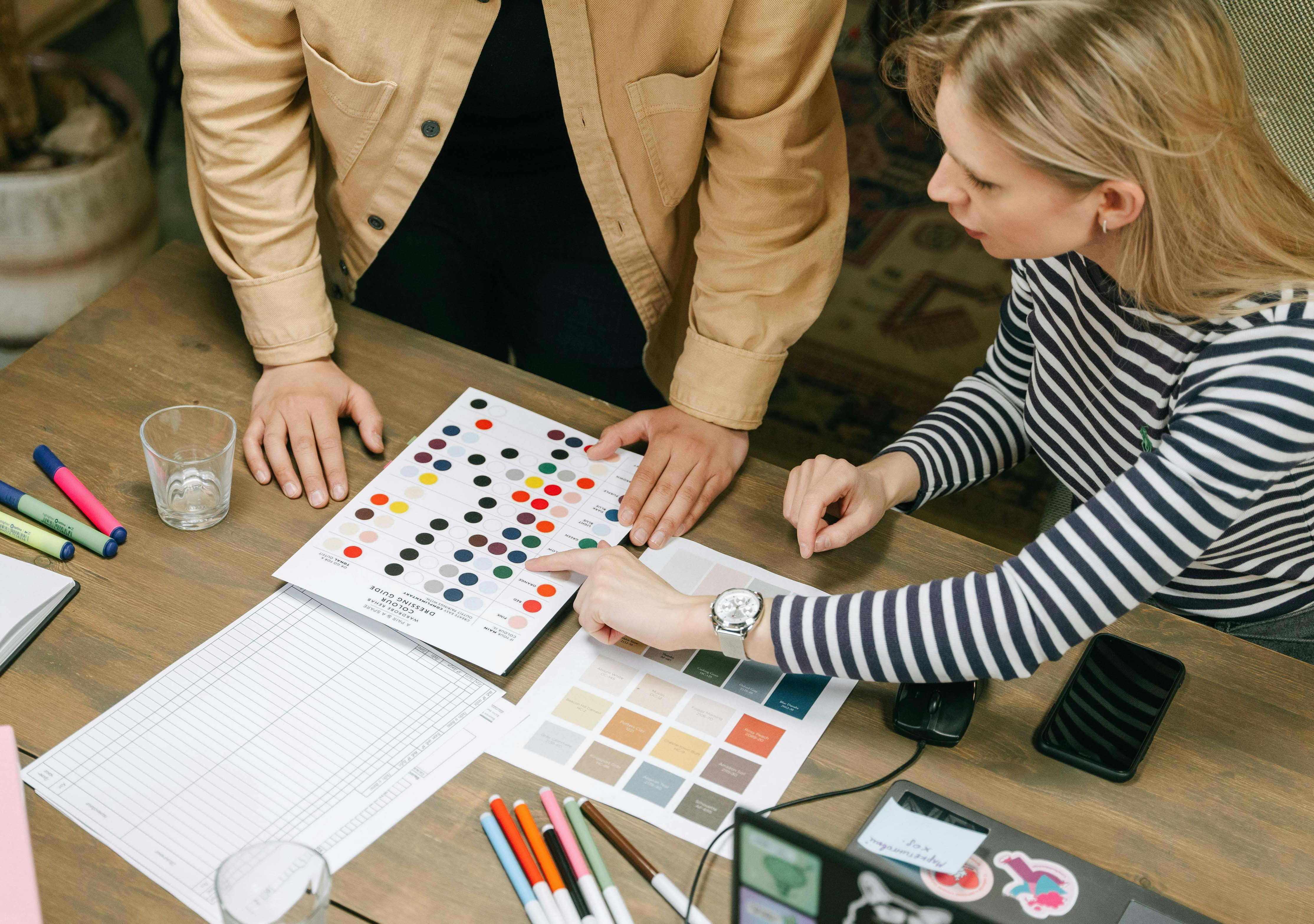 "Designers discussing real estate logo color schemes, showcasing color psychology and professional branding options for real estate logos."